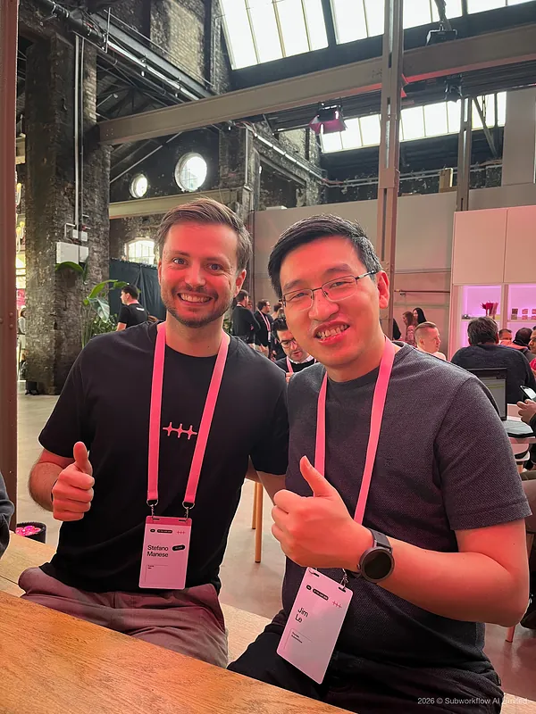 Jim and another attendee giving a thumbs up at a table